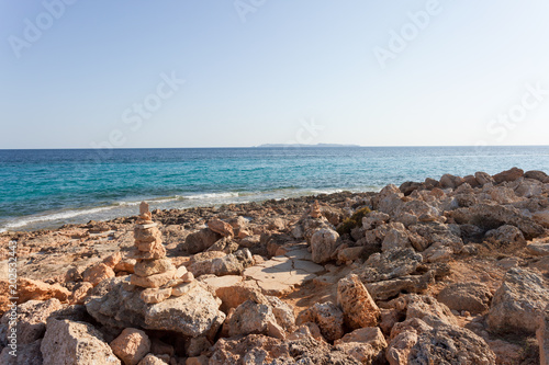 Cap de Ses Salines, Mallorca - The famous orange pebble stone at the beach of Ses Salines