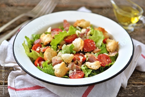 Salad with bacon, cherry tomatoes, lettuce, wheat crumbs, olive oil and lemon juice.