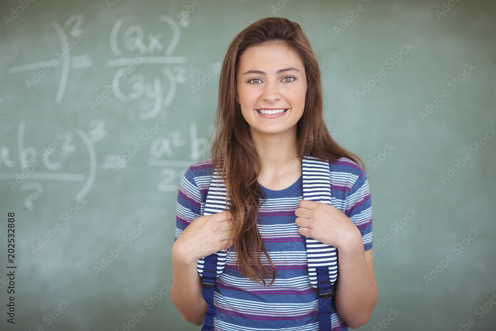 Portrait of schoolgirl standing in classroom