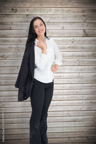 Pretty businesswoman smiling at camera against wooden planks background