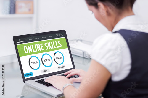 Online skills interface against businesswoman using laptop
