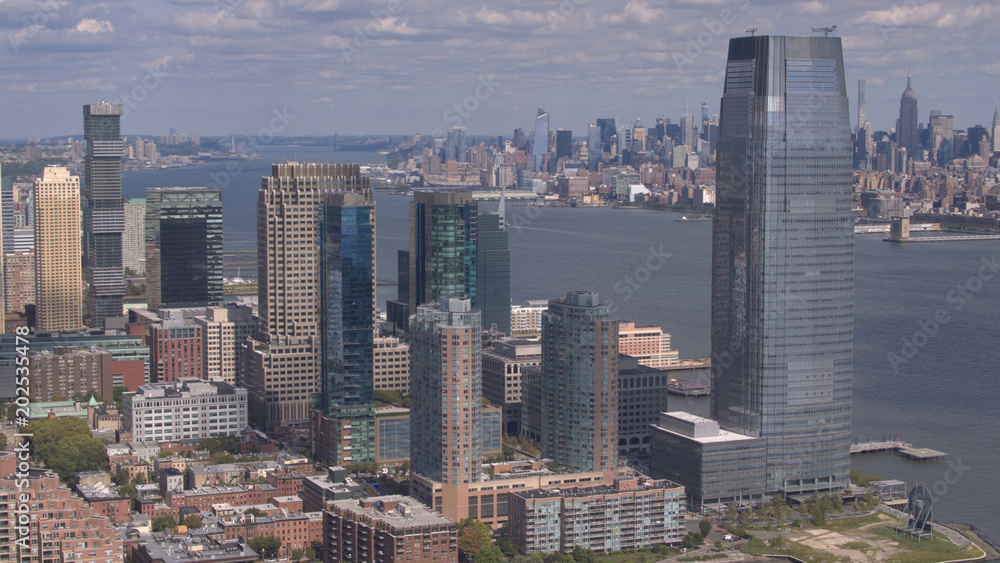 Obraz premium AERIAL: Flying around New Jersey downtown skyscrapers overlooking NY Manhattan