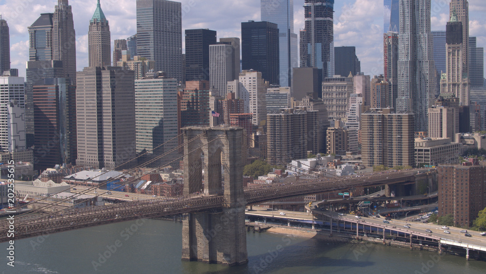 Naklejka premium AERIAL: Famous Brooklyn Bridge against Lower Manhattan downtown cityscape