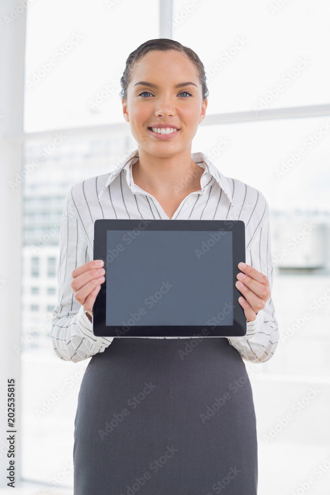 Smiling businesswoman showing tablet screen Smiling businesswoman showing tablet screen