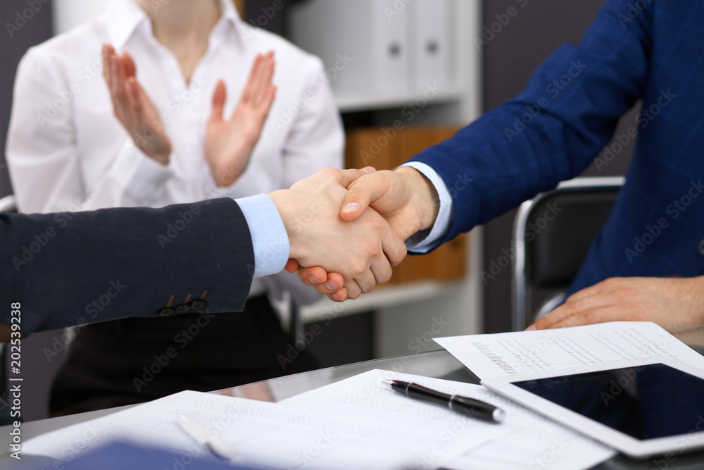 Business people shaking hands, finishing up a meeting. Audit, tax service or agreement concept Business people shaking hands, finishing up a meeting. Audit, tax service or agreement concept