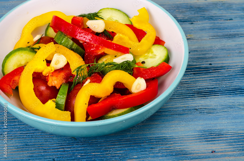 Summer vegetarian fresh vegetable salad on blue wooden background Summer vegetarian fresh vegetable salad on blue wooden background