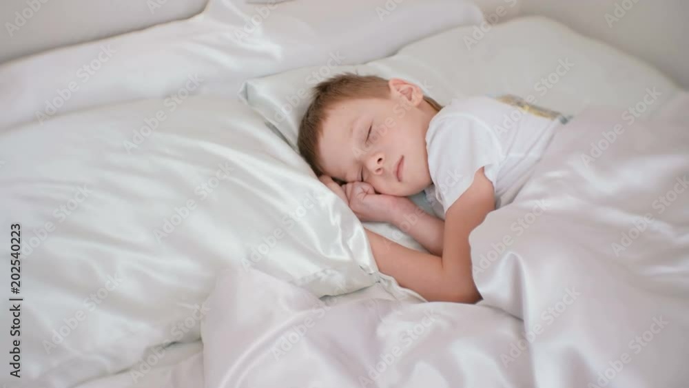 Seven-year-old boy alarmingly sleeping in his bed. Seven-year-old boy alarmingly sleeping in his bed.