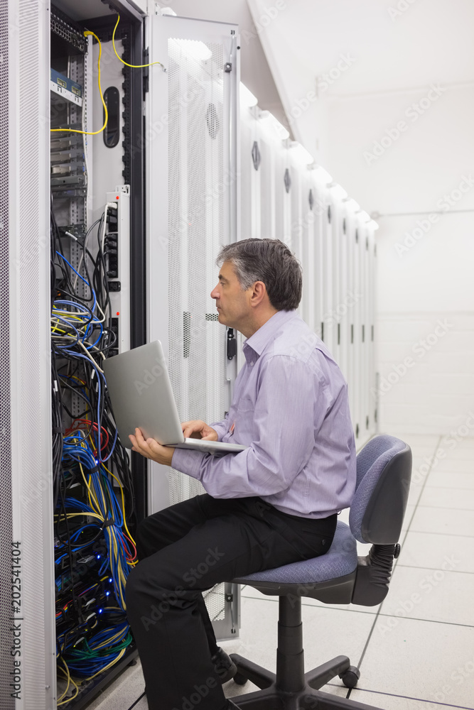 Technician checking the server with his laptop