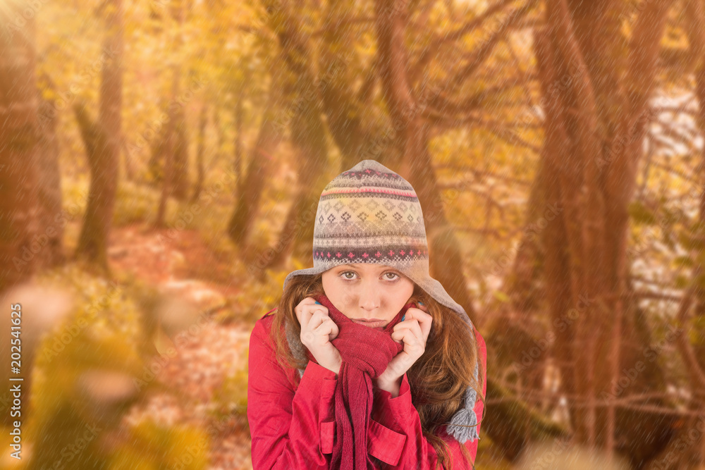 Cold redhead wearing coat and hat against tranquil autumn scene in forest Cold redhead wearing coat and hat against tranquil autumn scene in forest