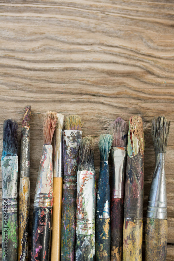 Fototapeta premium Various dirty paintbrush arranged in a row