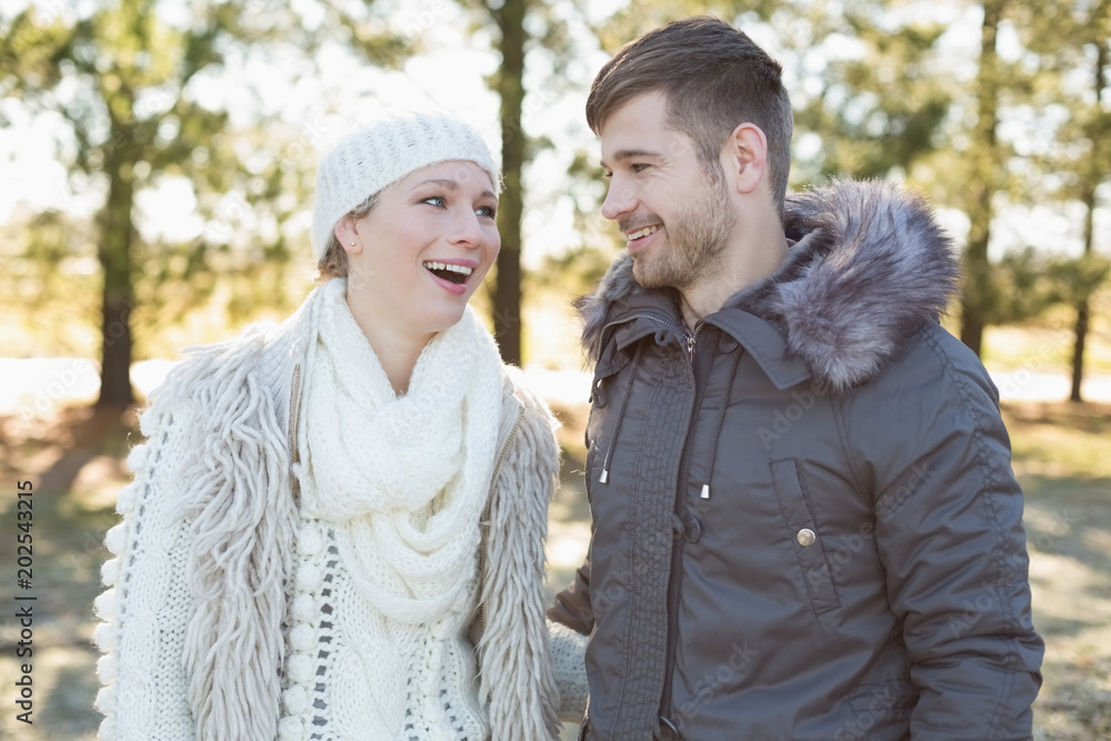 Fototapeta premium Cheerful couple in winter clothing in the woods