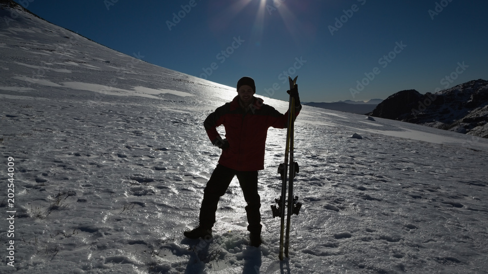 Silhouette man with ski board standing on snow