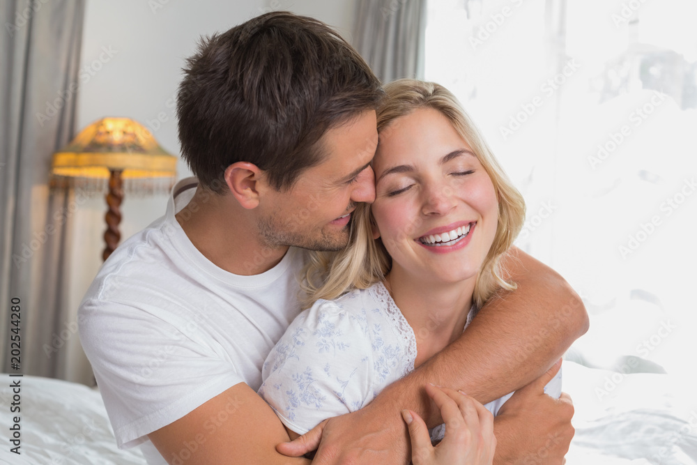 Loving man embracing woman from behind at home Loving man embracing woman from behind at home