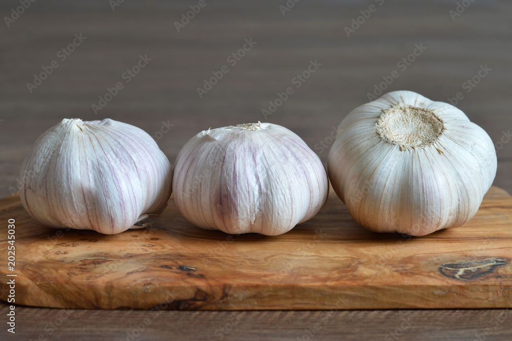 Obraz premium Garlic bulbs on wooden board