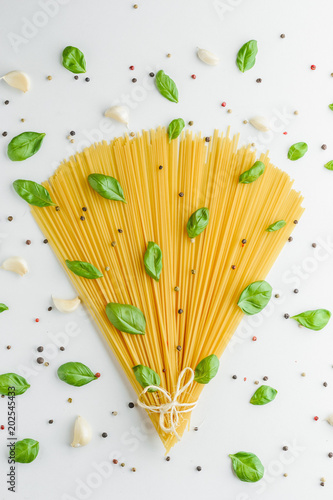 Concept food with pasta, basil, garlic and pepper on a white background