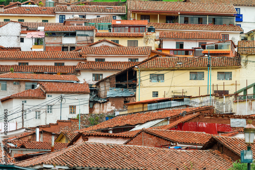 Tiled roofs of houses on the side of a hill in Cusco (Peru)