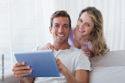 Portrait of a happy couple using digital tablet