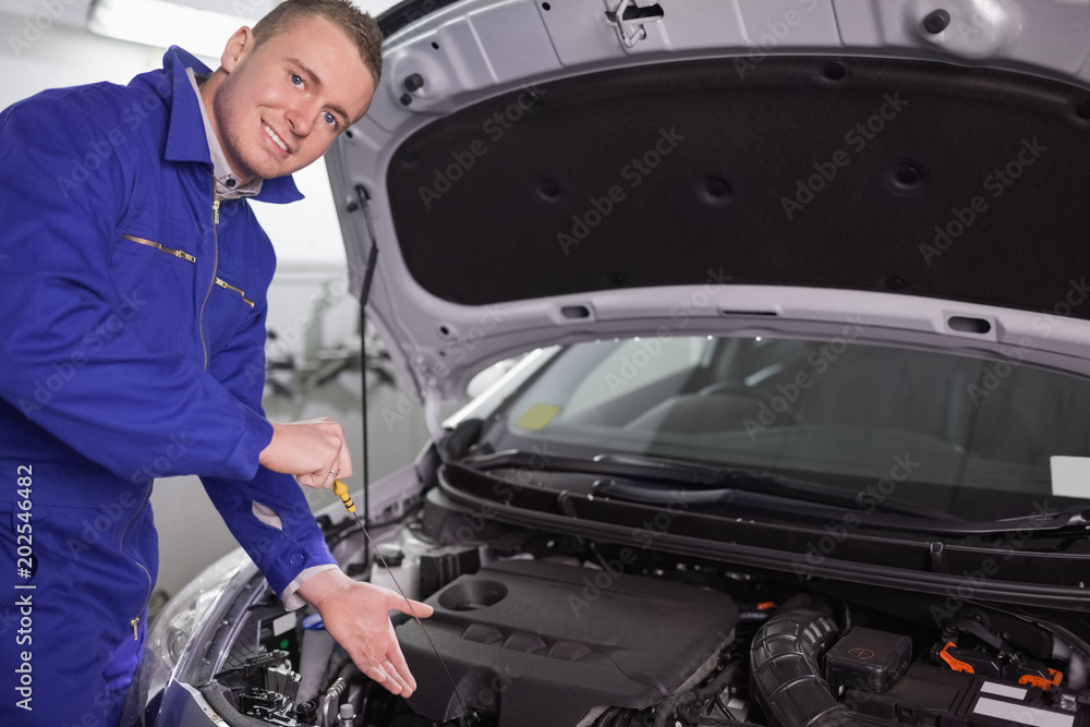 Mechanic showing an engine with his hand Mechanic showing an engine with his hand