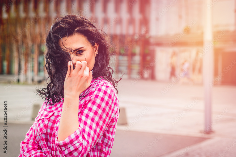 Beautiful and smiling girl poses for photos. A young woman smiling at the camera hidding face with hand and hairs. Authenticity and Spontaneity. Beautiful and smiling girl poses for photos. A young woman smiling at the camera hidding face with hand and hairs. Authenticity and Spontaneity.
