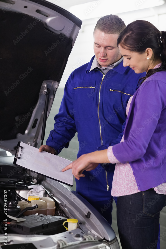 Woman looking at the clipboard next to a car Woman looking at the clipboard next to a car