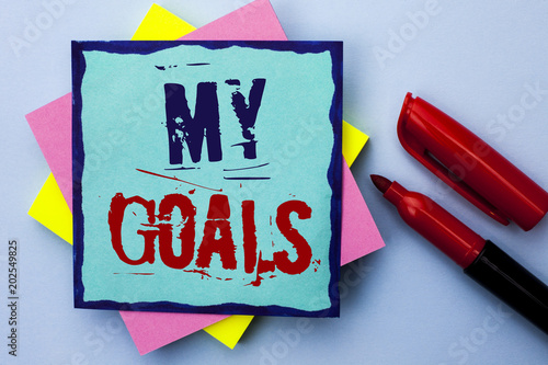 Writing note showing  My Goals. Business photo showcasing Goal Aim Strategy Determination Career Plan Objective Target Vision written on Sticky Note Paper on the Plain background Marker next to it. photo