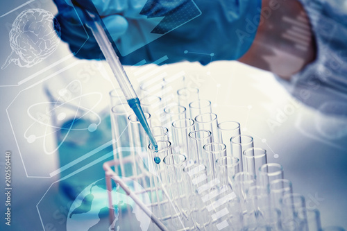 Protected hand dropping liquid in test tubes against science and medical graphic photo