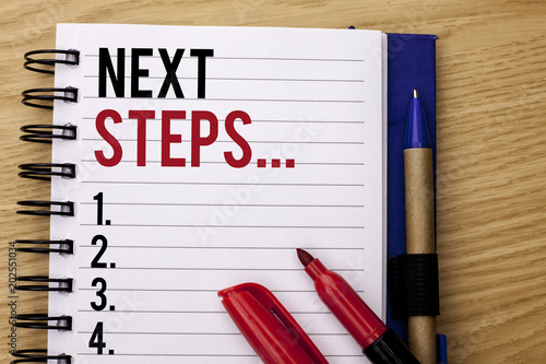 Handwriting text writing Next Steps.... Concept meaning Following Moves Strategy Plan Give Directions Guideline written on Notebook Book on the wooden background Marker and Pencil next to it.
