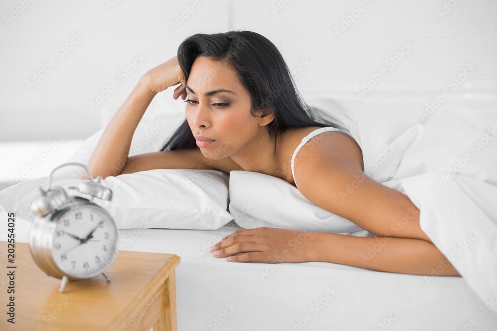 Exhausted young woman lying in her bed Exhausted young woman lying in her bed