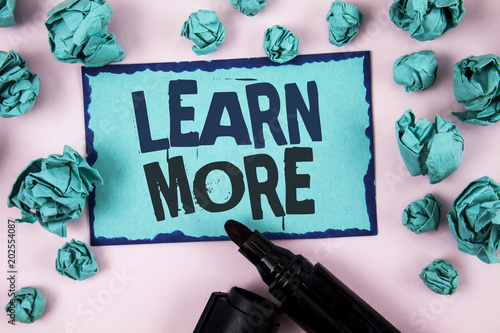 Word writing text Learn More. Business concept for Study harder Develop new skills abilities Get extra education written on Sticky Note paper on plain Pink background Paper Balls and Marker.