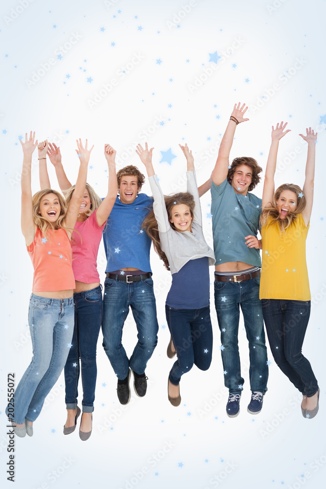 Celebrating friends jumping in the air against snow falling Celebrating friends jumping in the air against snow falling