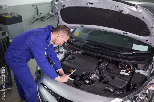 Concentrated mechanic repairing a car