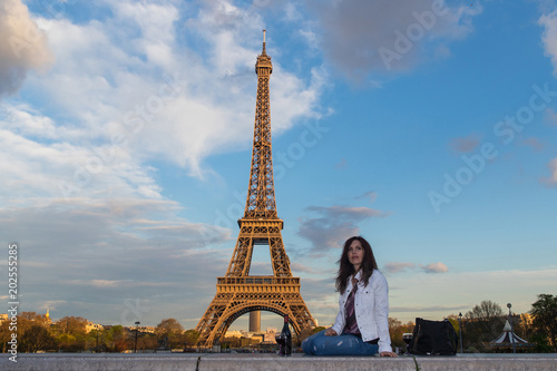 Beautiful woman drinking a glass of wine at the Eiffel Tower in Paris, France