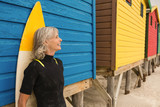 Smiling senior woman standing by blue hut