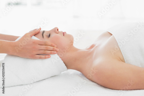 Hands massaging womans face at beauty spa