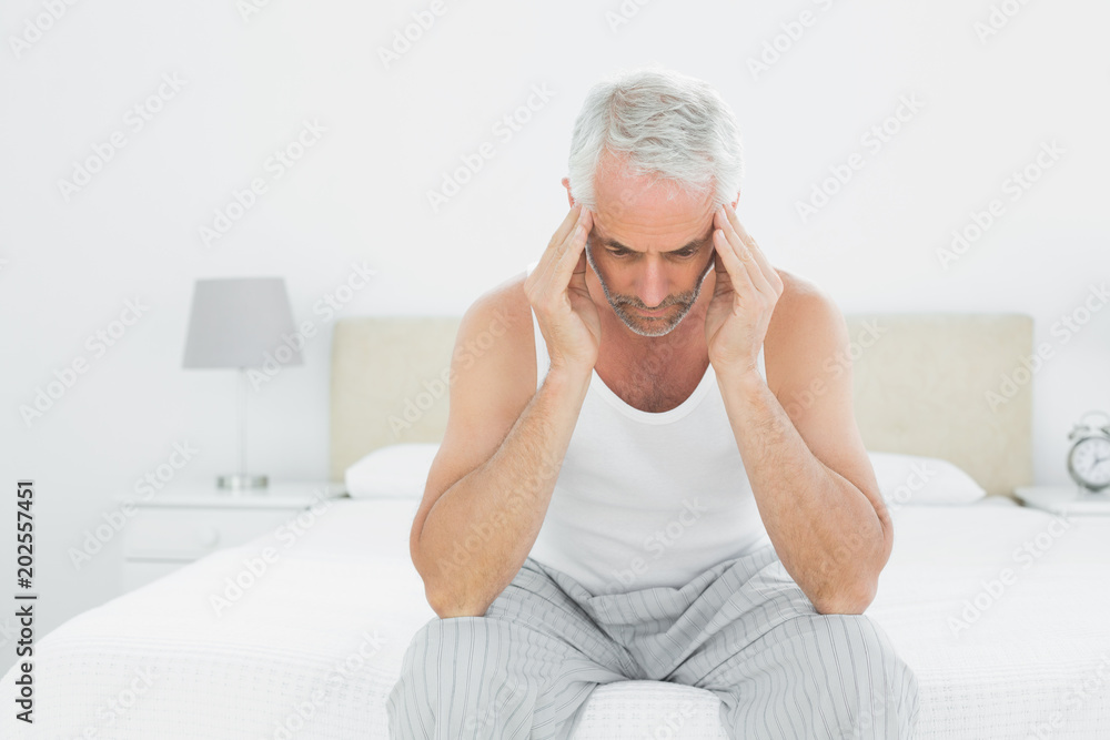 Man suffering from headache in bed Man suffering from headache in bed