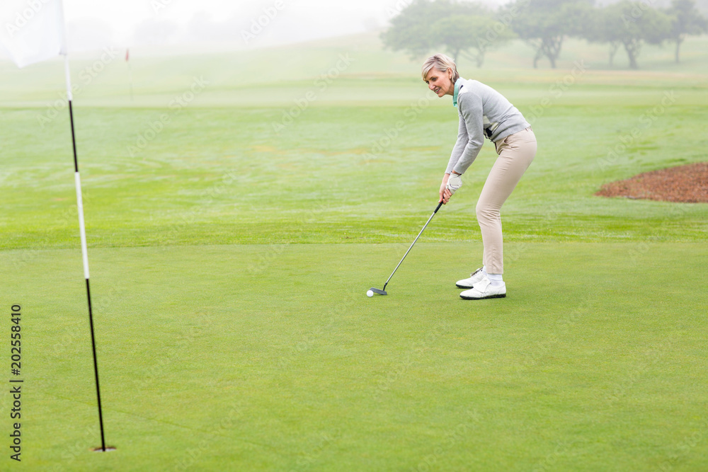Obraz premium Lady golfer on the putting green