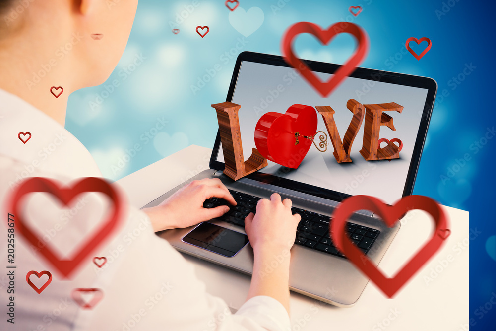 Fotografie Businesswoman using her laptop against valentines heart design