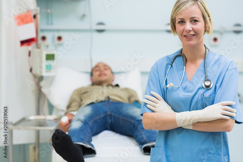 Nurse next to a male patient with arms crossed