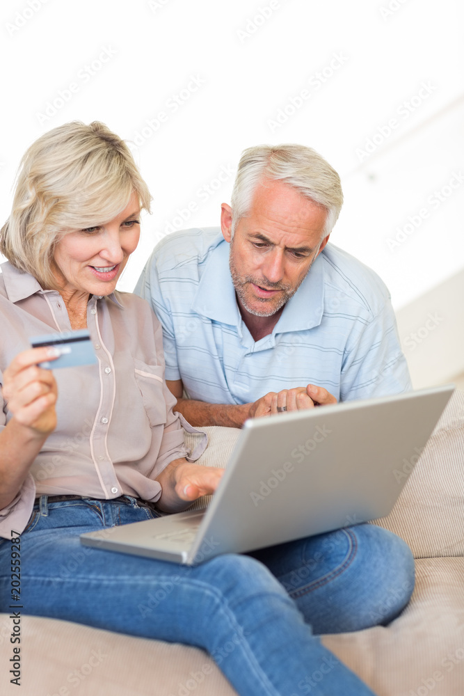 Mature couple doing online shopping at home Mature couple doing online shopping at home