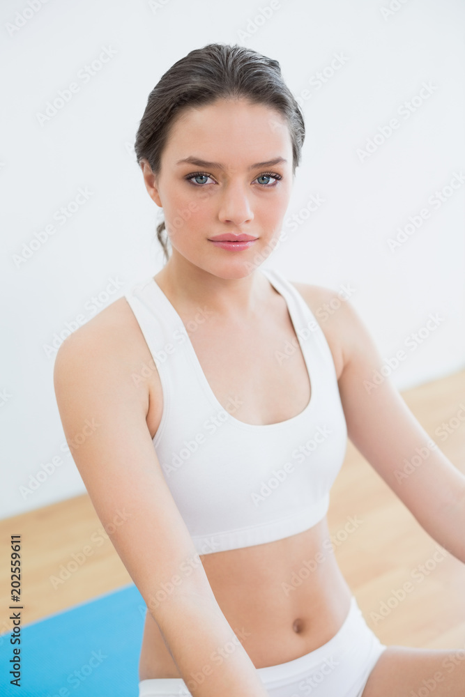 Toned brunette sitting at fitness studio