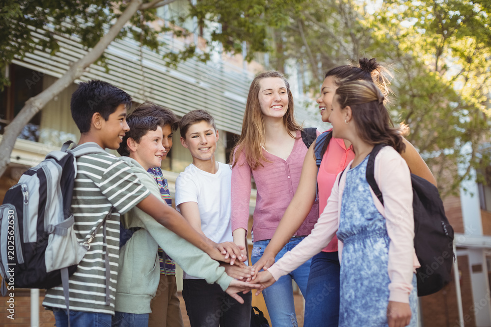 Happy school kids forming hand stack in campus Happy school kids forming hand stack in campus