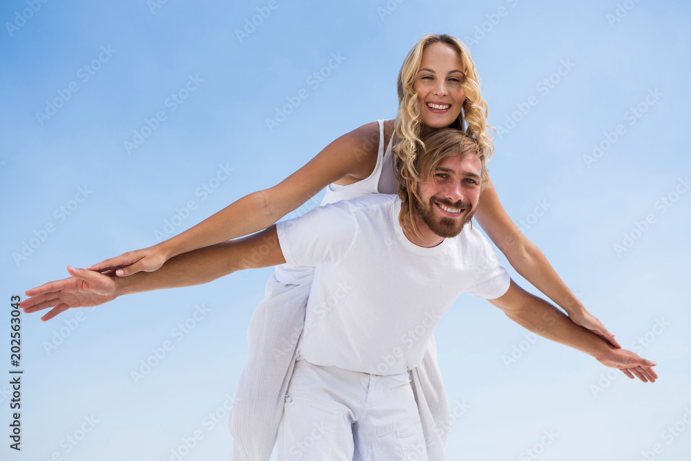 Low angle portrait of man piggybacking girlfriend Low angle portrait of man piggybacking girlfriend
