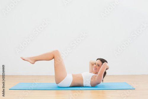 Sporty woman doing sits up at fitness studio