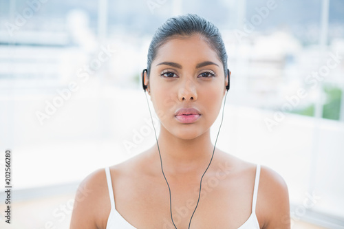 Unsmiling toned brunette listening to music Free Download Unsmiling toned brunette listening to music - GFXLoad
