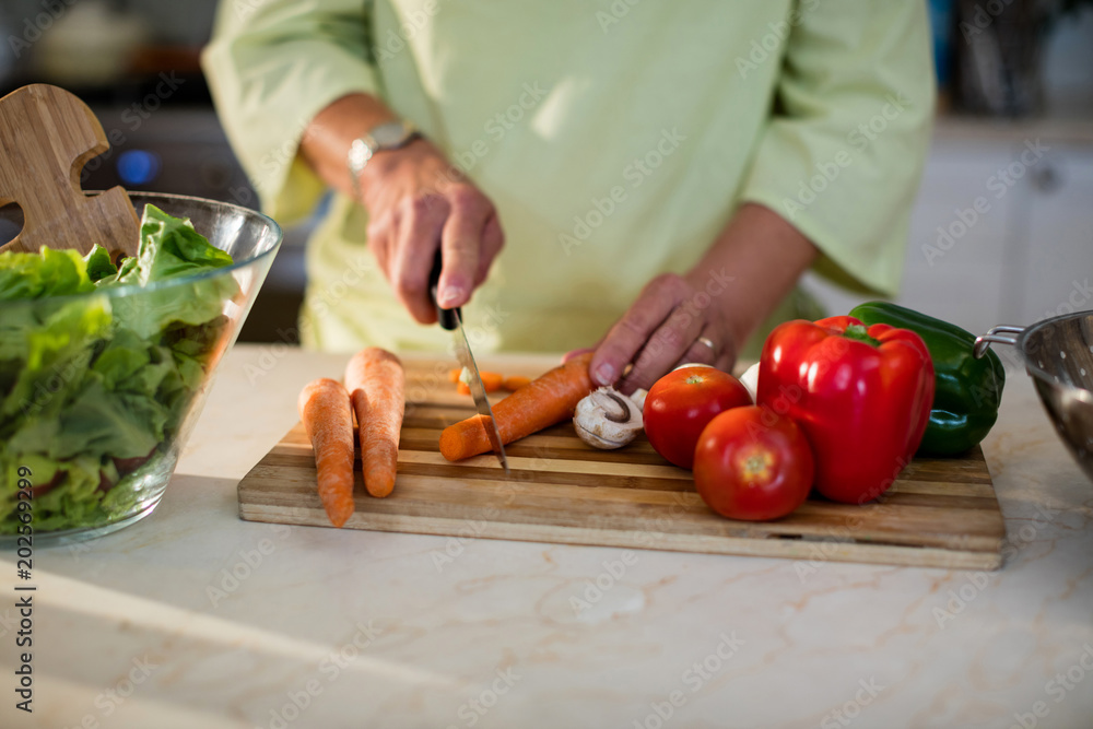 Senior woman cutting vegetables for salad Senior woman cutting vegetables for salad