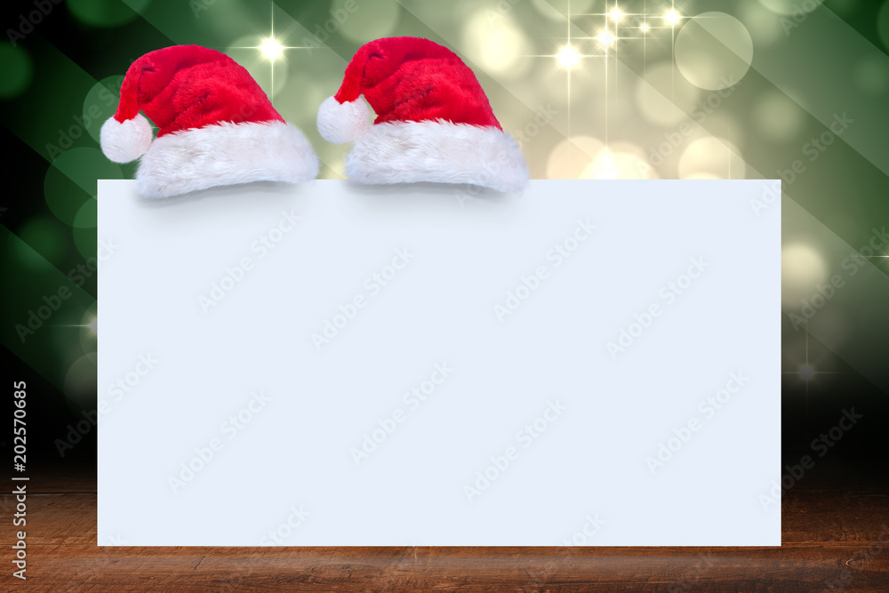 Fototapeta premium Santa hat on poster against shimmering light design over boards