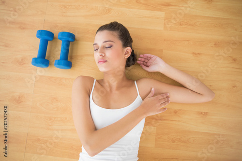 Pretty natural brown haired woman in white sportswear sleeping on the floor © WavebreakmediaMicro