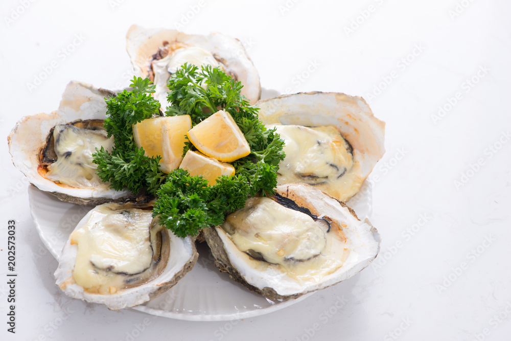 Opened oysters, ice and lemon on wooden board over stone table. Half dozen. With copy space
