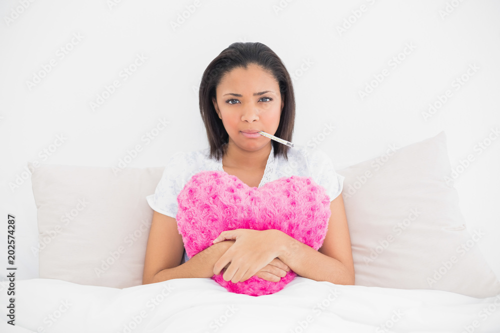 Anxious young dark haired model using a thermometer Anxious young dark haired model using a thermometer