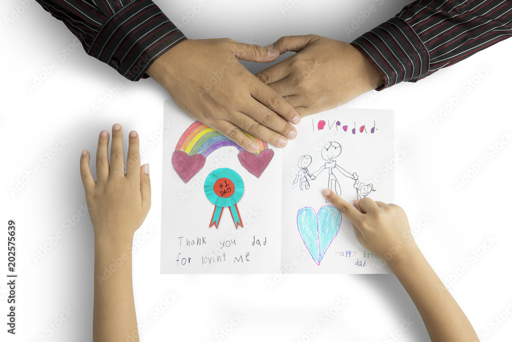 Hands of father and child with greeting card